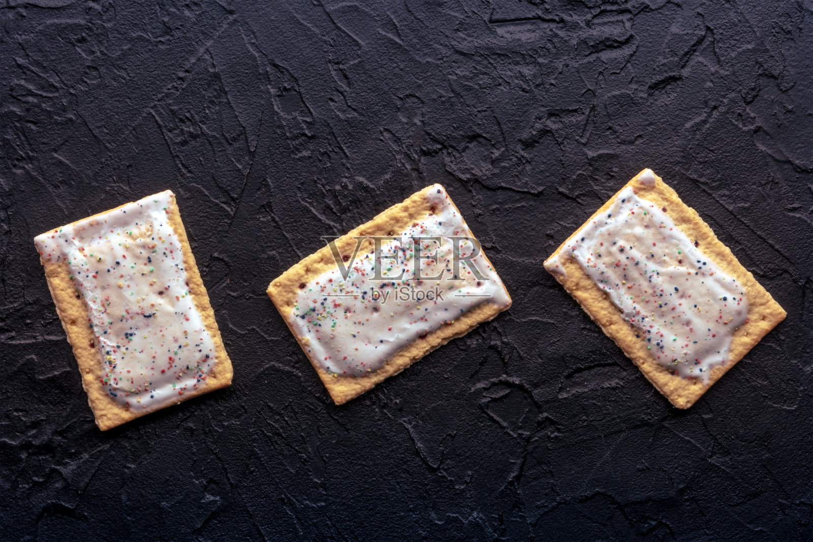 流行挞。黑底糖霜烤面包饼，放在头顶照片摄影图片