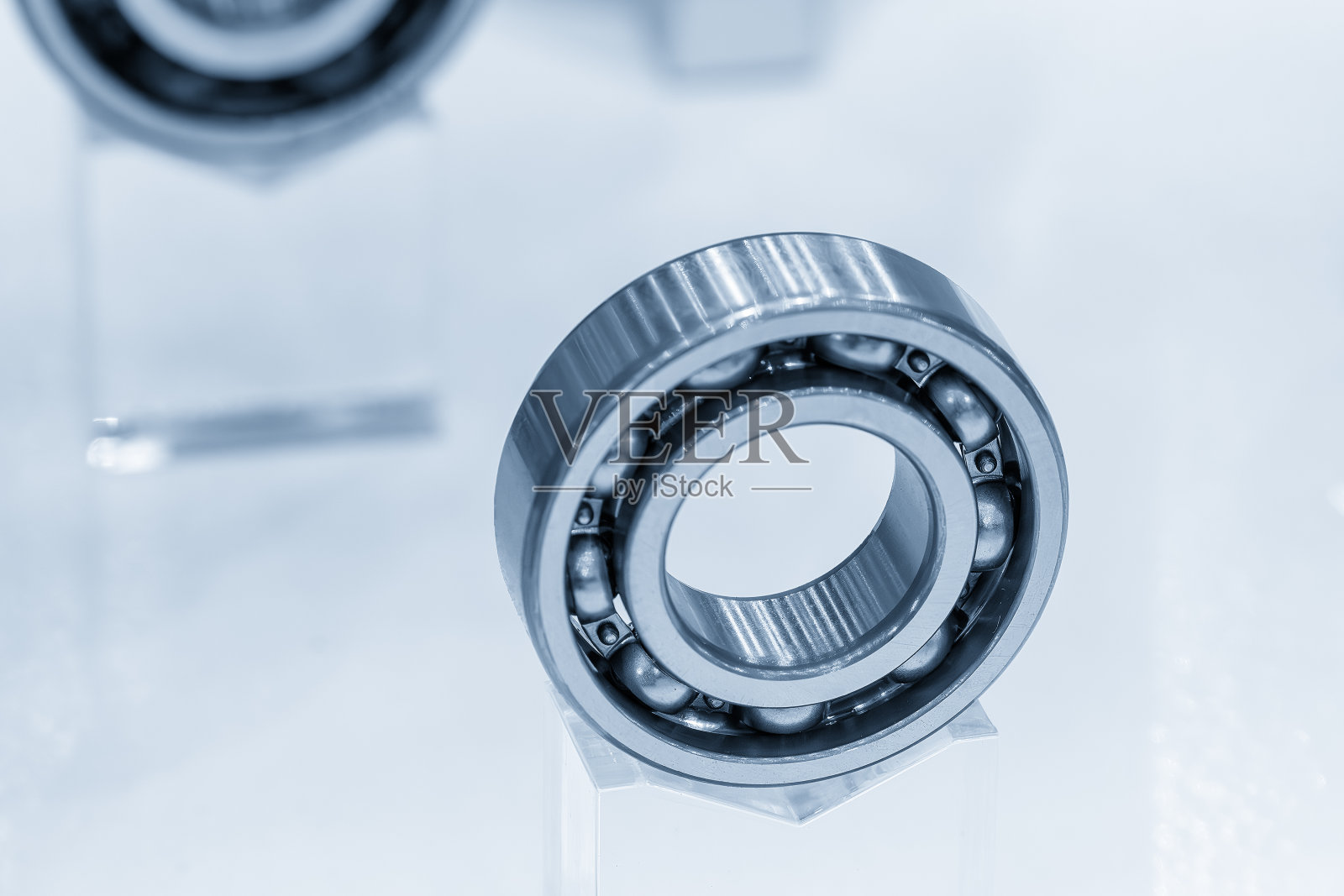 特写场景中球轴承部分在淡蓝色的场景中。照片摄影图片