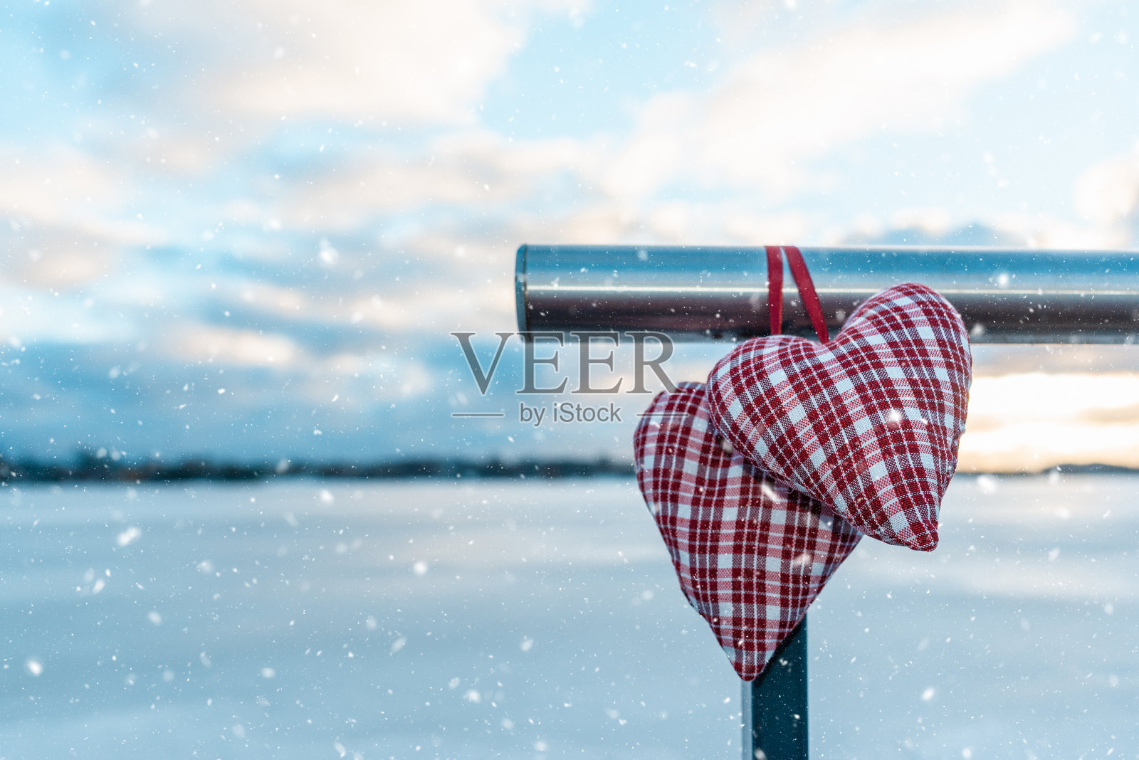 情侣情人的心阴云迷离的背景衬着冬天的风景。下雪了。情人节概念。照片摄影图片