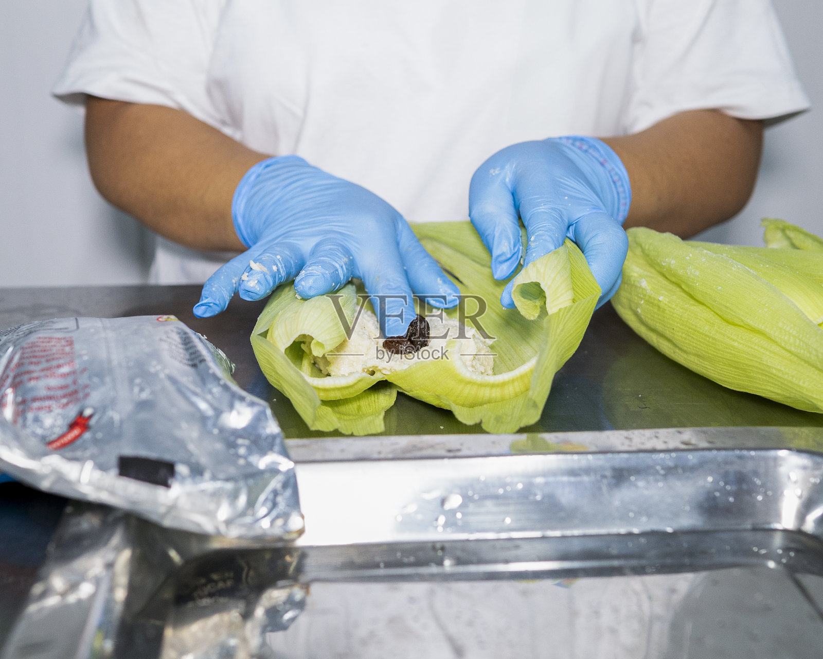 准备和包装面团，秘鲁甜humitas。照片摄影图片