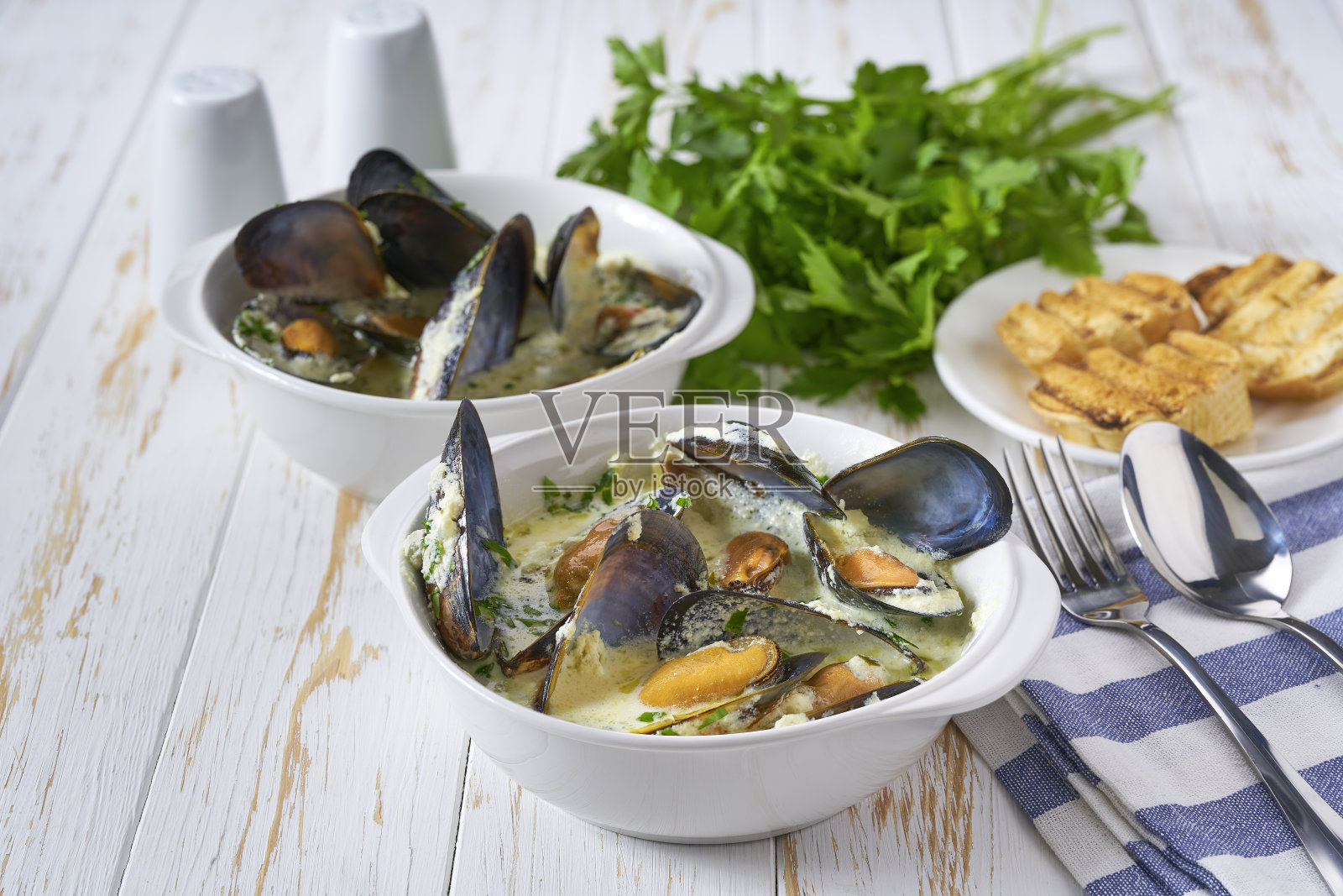 白桌子上的一碗海鲜杂烩配贻贝和虾。照片摄影图片