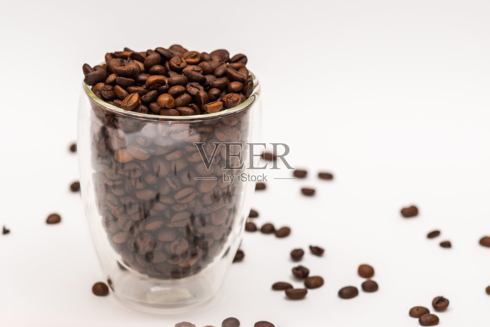 白色背景上的咖啡豆。透明的杯子照片摄影图片
