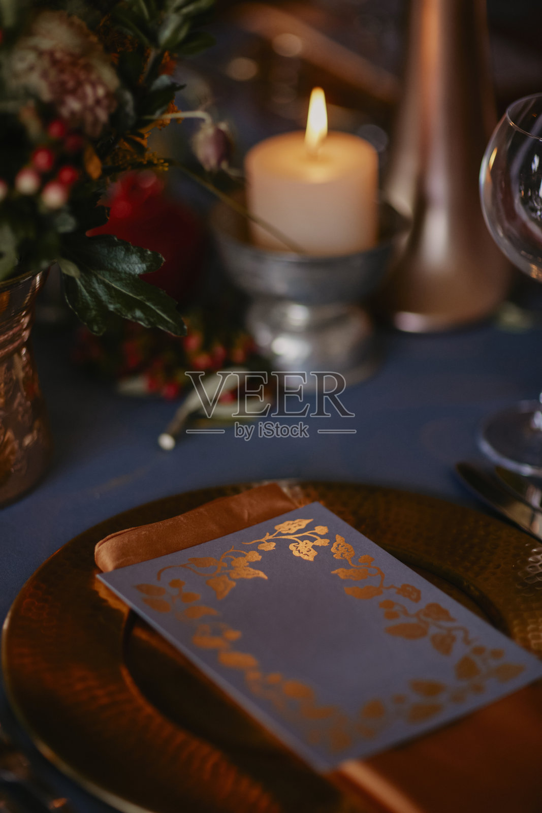 波希米亚风格的婚礼餐桌，装饰着一个蓝色覆盖的青铜花瓶和石榴雕像。库存图片照片摄影图片