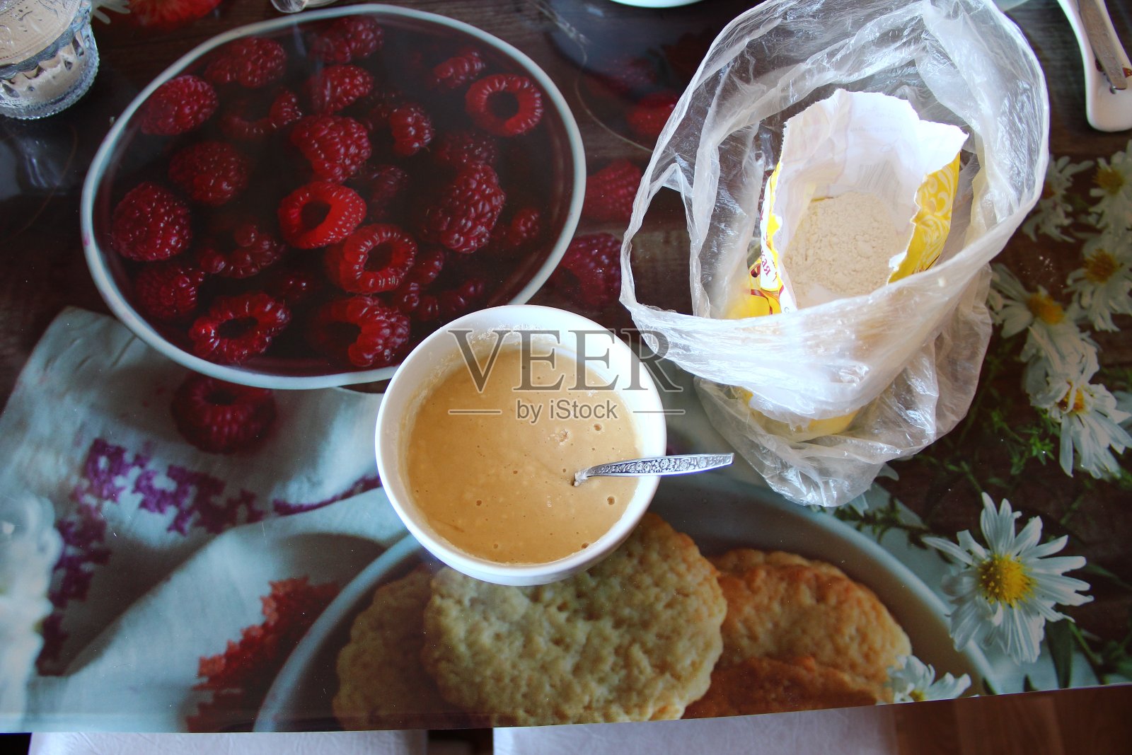 生面团放在盘子里，面粉放在桌子上照片摄影图片