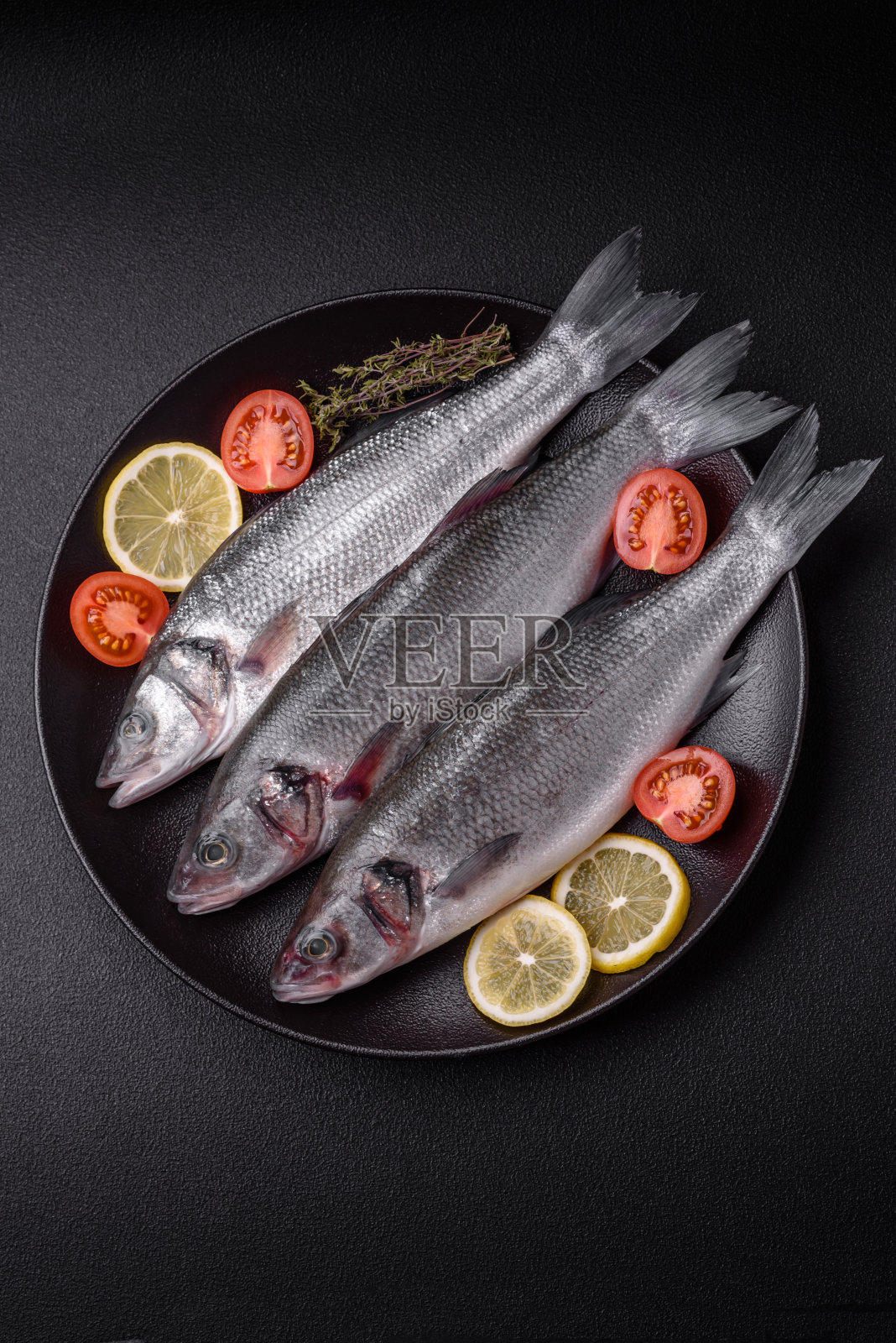 新鲜的海鲈鱼，加盐，香料和香草照片摄影图片