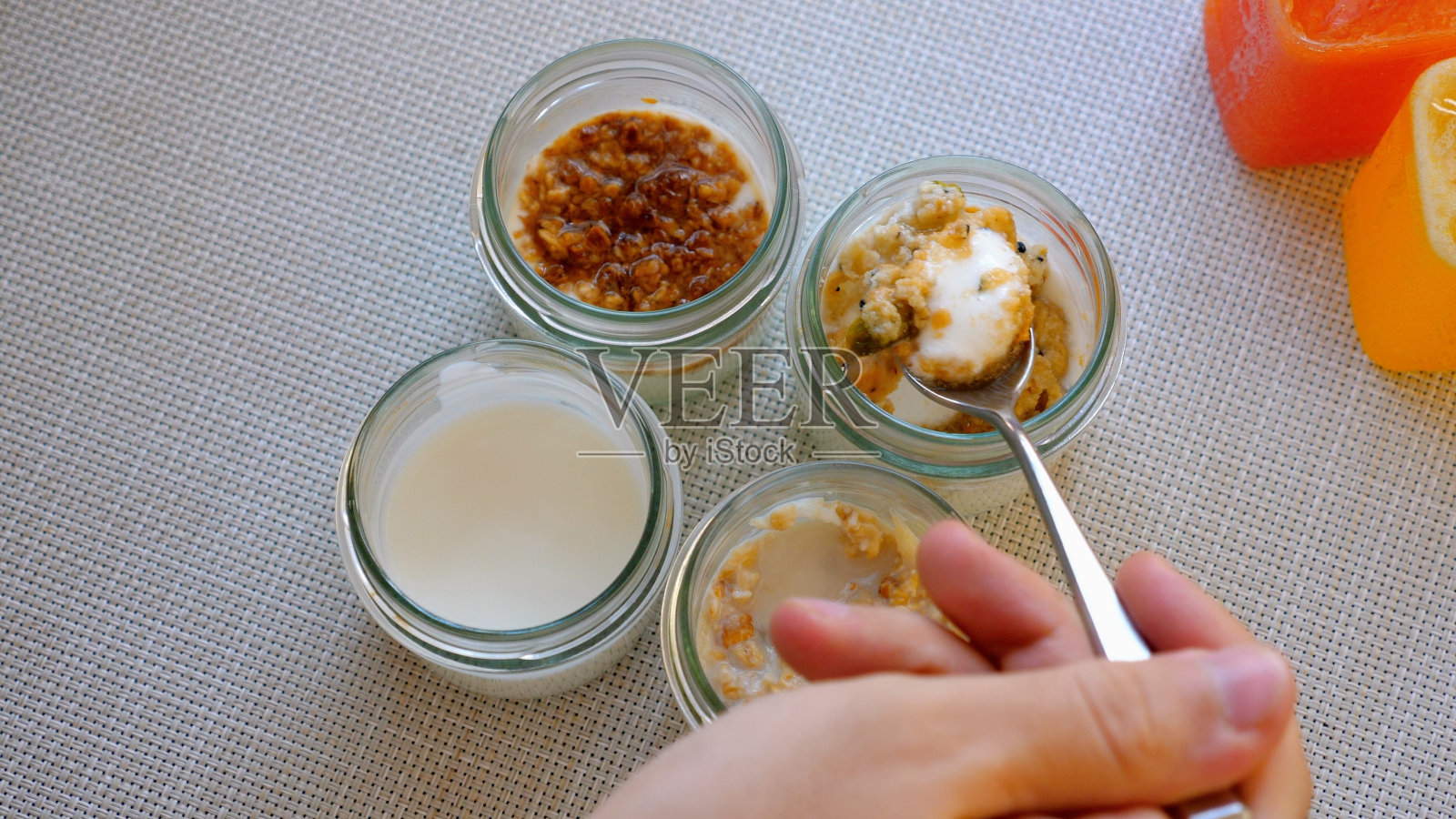 一个人拿着勺子站在四罐食物前照片摄影图片