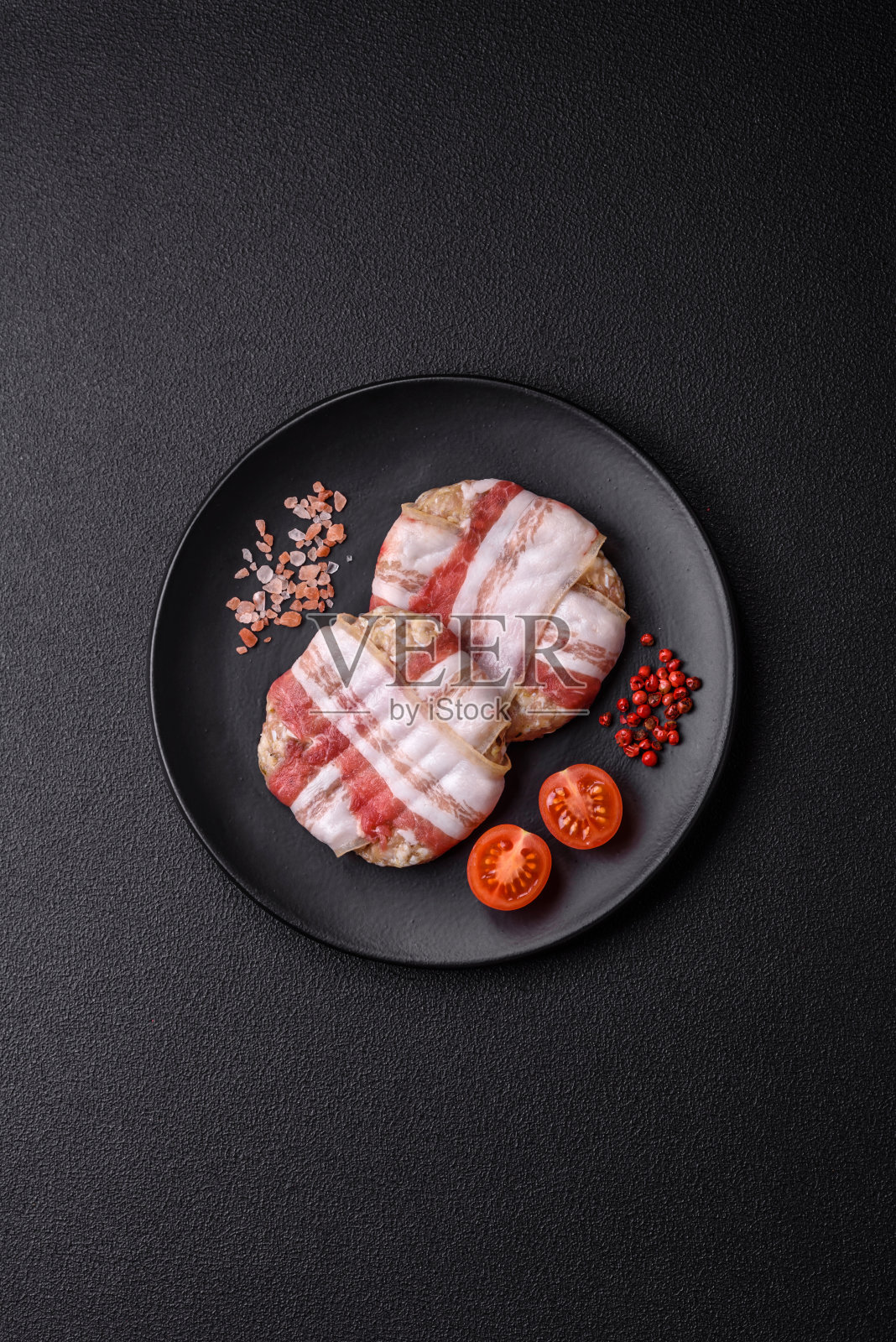 用盐、香料和香草包着的圆形鸡肉或猪肉片照片摄影图片