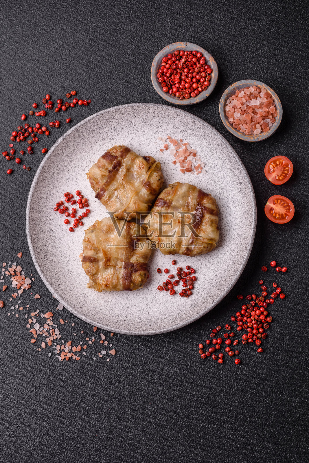 用盐、香料和香草包着的圆形鸡肉或猪肉片照片摄影图片