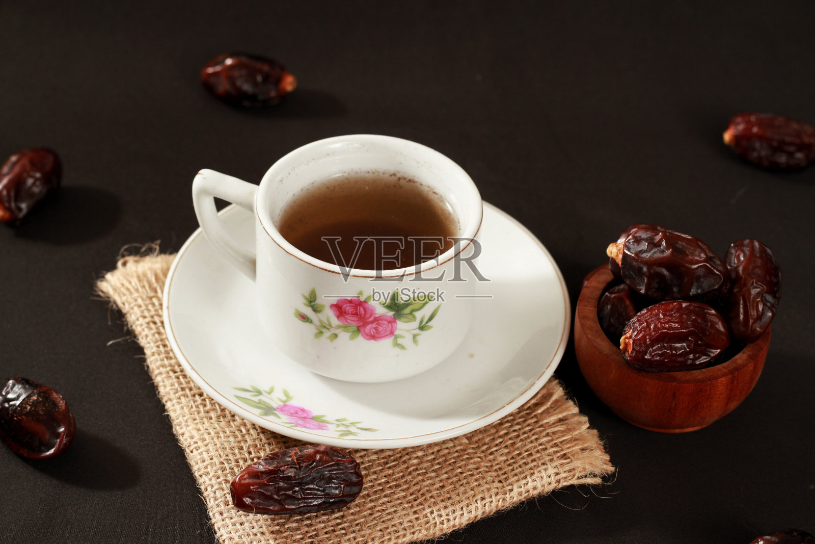 库尔玛(Kurma)或在木碗里装枣子，茶在孤立的白色背景上，是斋月开斋时流行的食物，是斋月的概念照片摄影图片