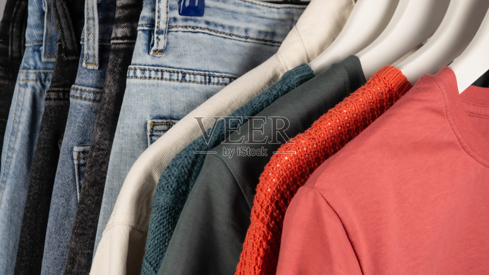 衣架上的牛仔裤。休闲服。摩登、青春的女式牛仔西裤。在商店购物。照片摄影图片