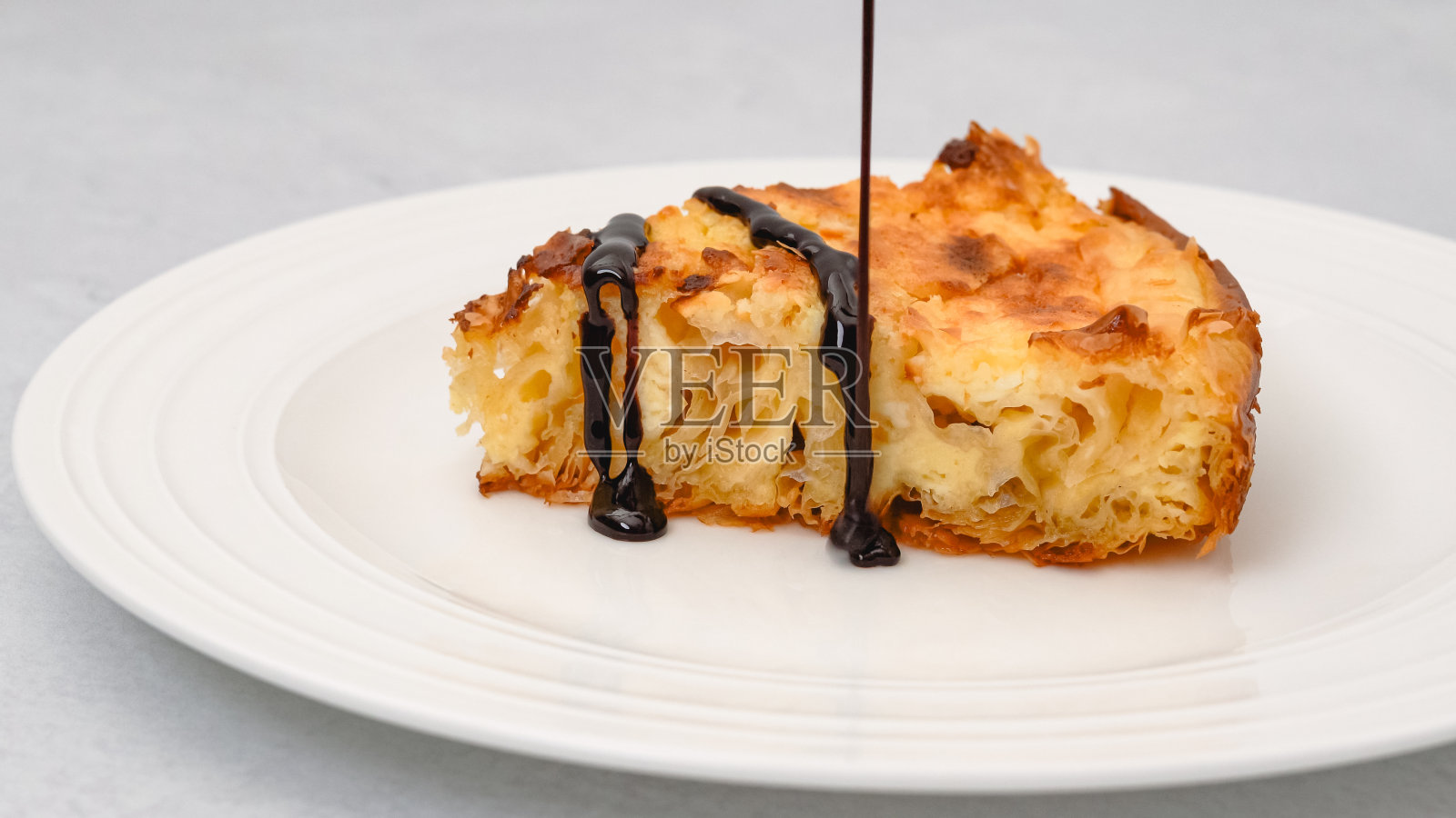 白色盘子里的一片菲罗面团派，里面有奶油芝士和巧克力酱照片摄影图片