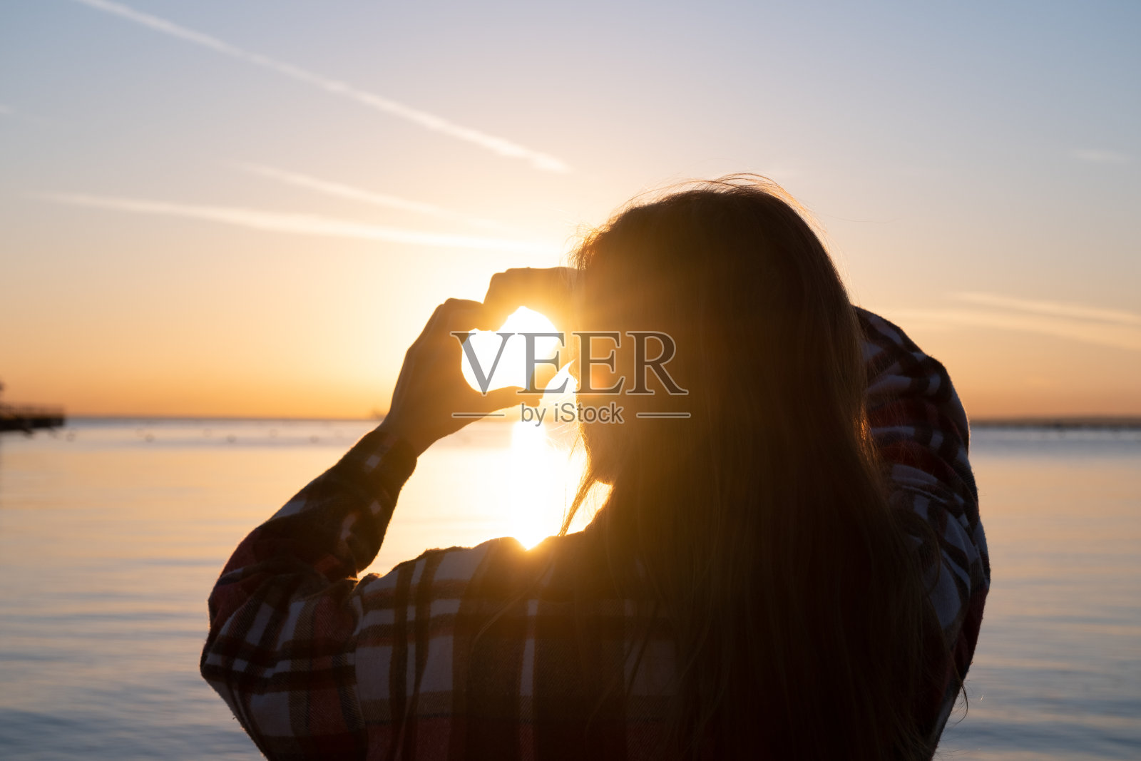 手与日落剪影形成心形照片摄影图片