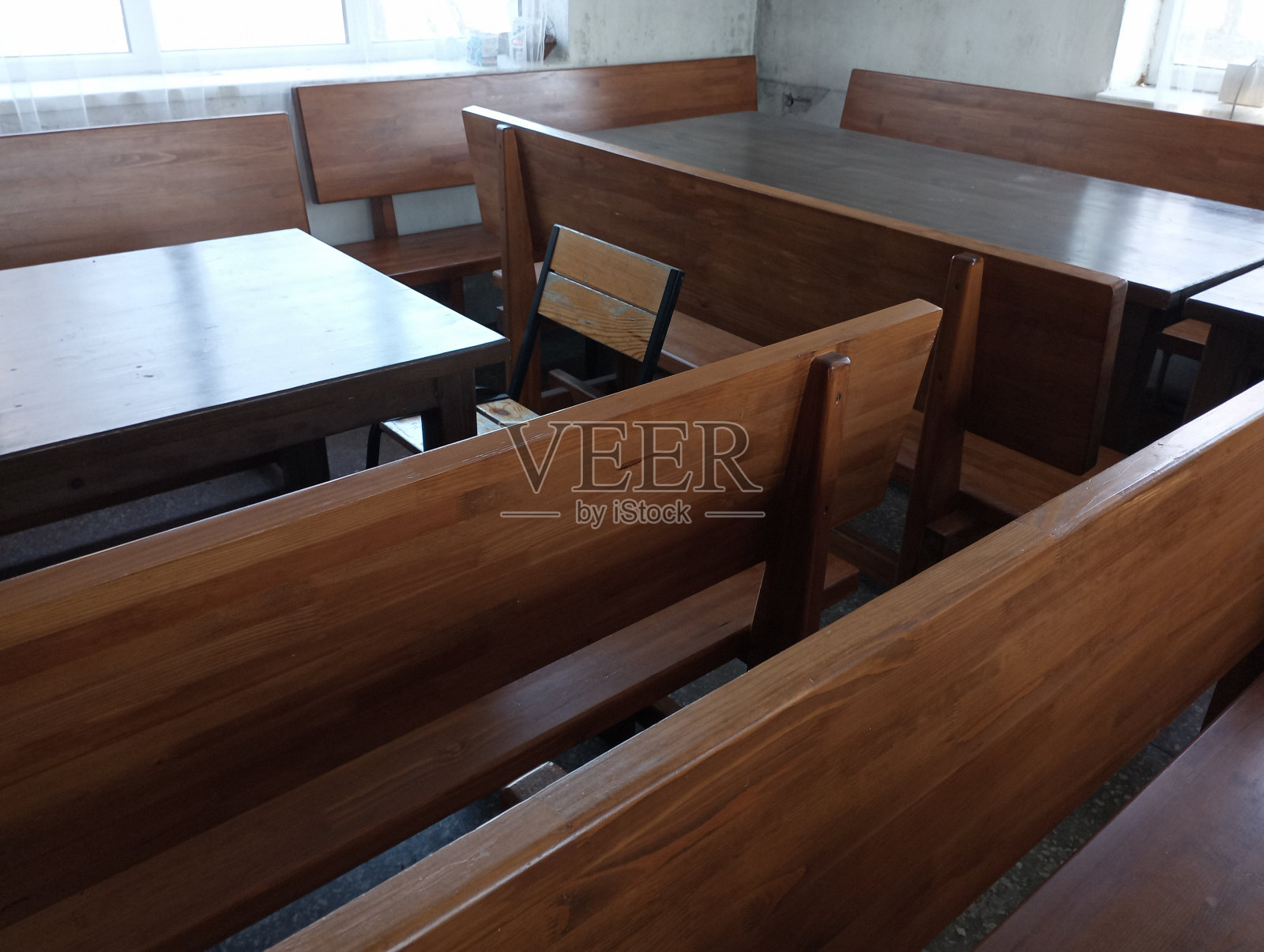 有大木桌和长凳的餐厅。实木漆厨房家具。照片摄影图片