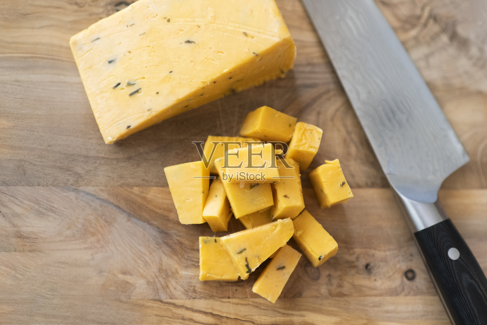 俯视图，一把刀放在木制砧板上，上面放着大块的英国切达奶酪照片摄影图片