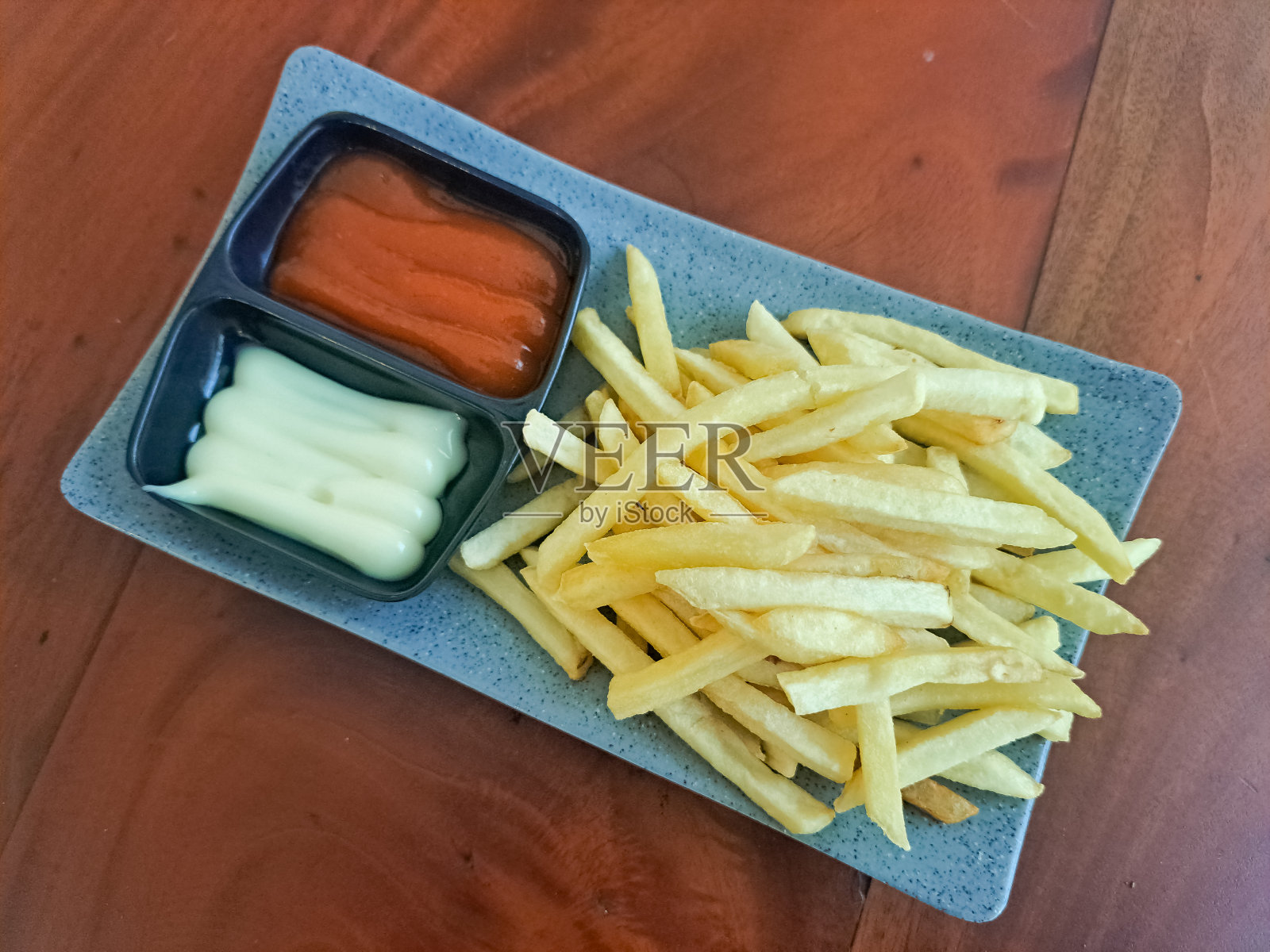 盘子里的薯条配辣酱和蛋黄酱。小吃菜单。照片摄影图片