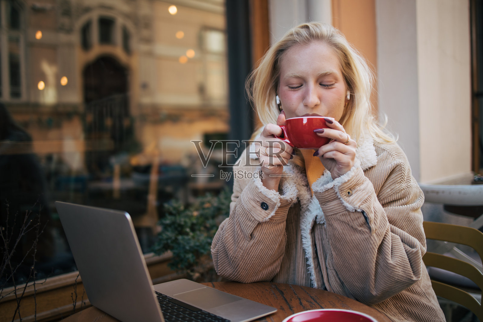 年轻的白化病妇女在咖啡馆使用笔记本电脑照片摄影图片