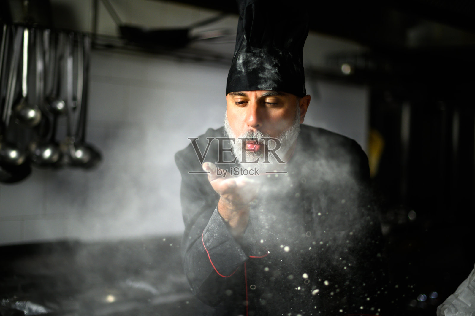 厨师用手掌吹面粉照片摄影图片