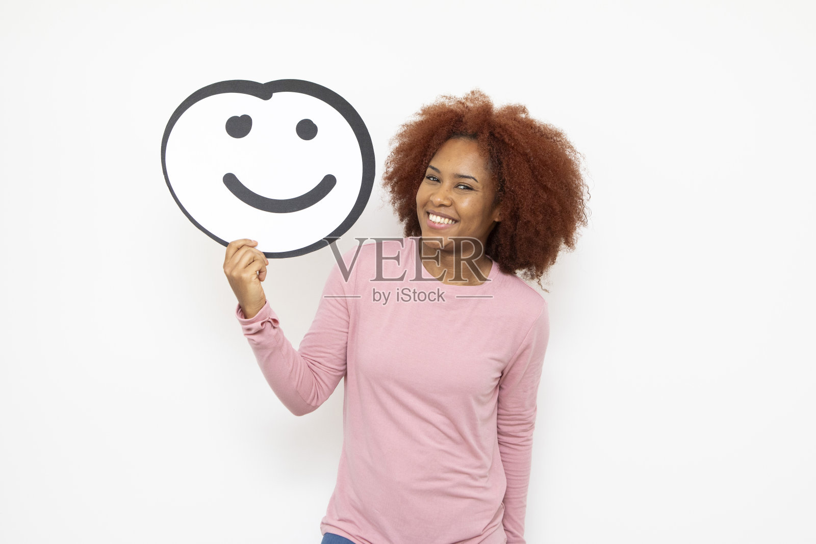 一个女人拿着一张拟人化的笑脸照片摄影图片