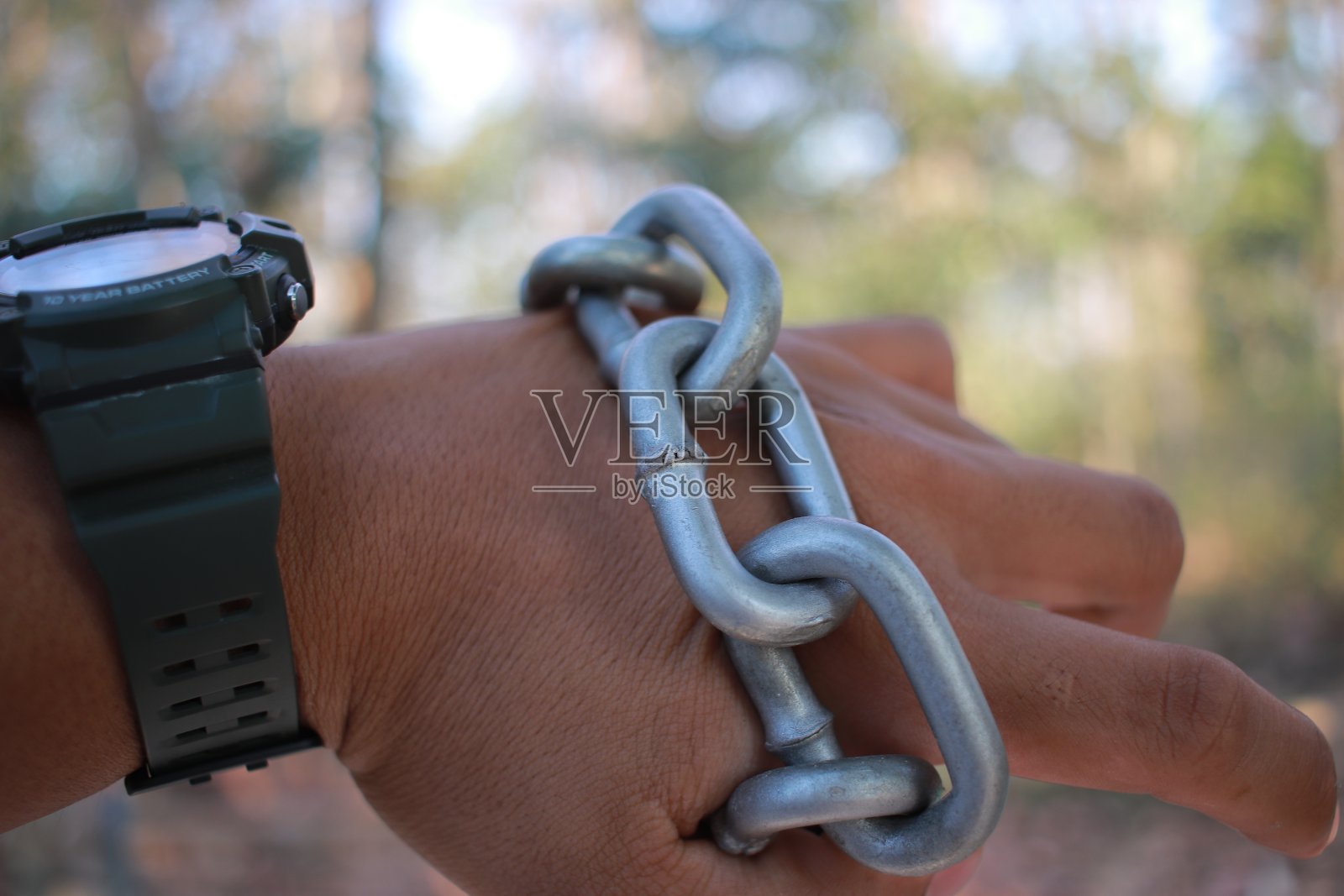 男人手里拿着沉重的链子照片摄影图片