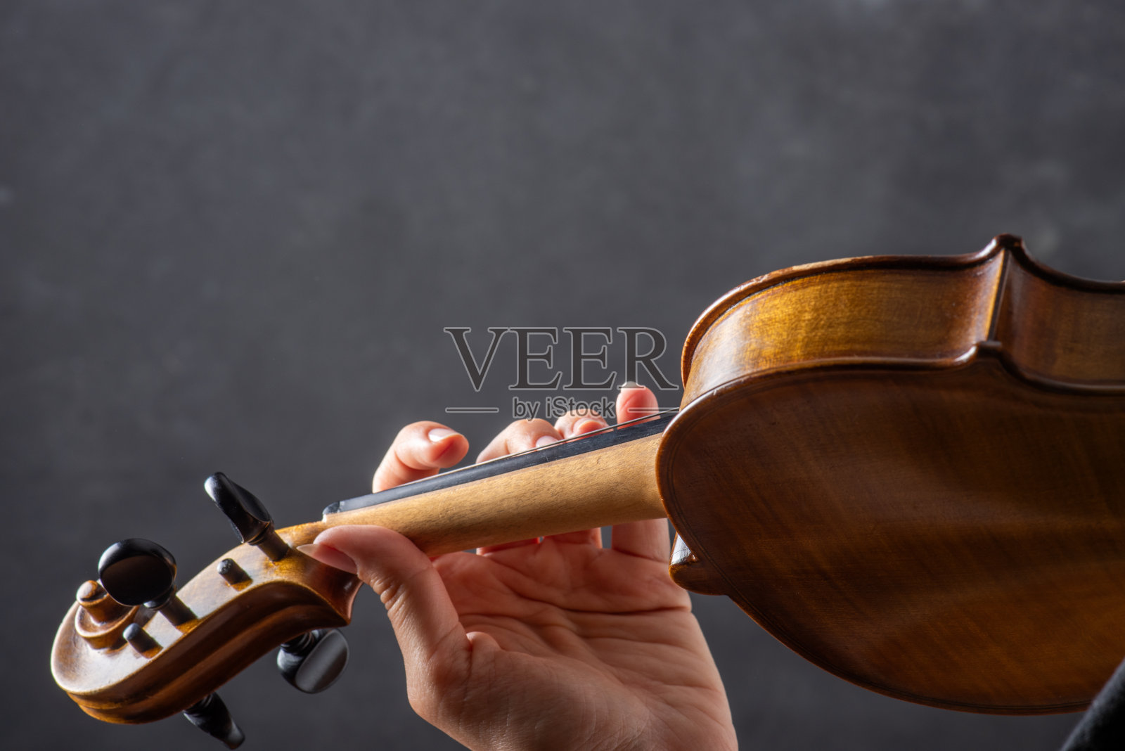 拉小提琴的人伸出握着琴弓的手照片摄影图片