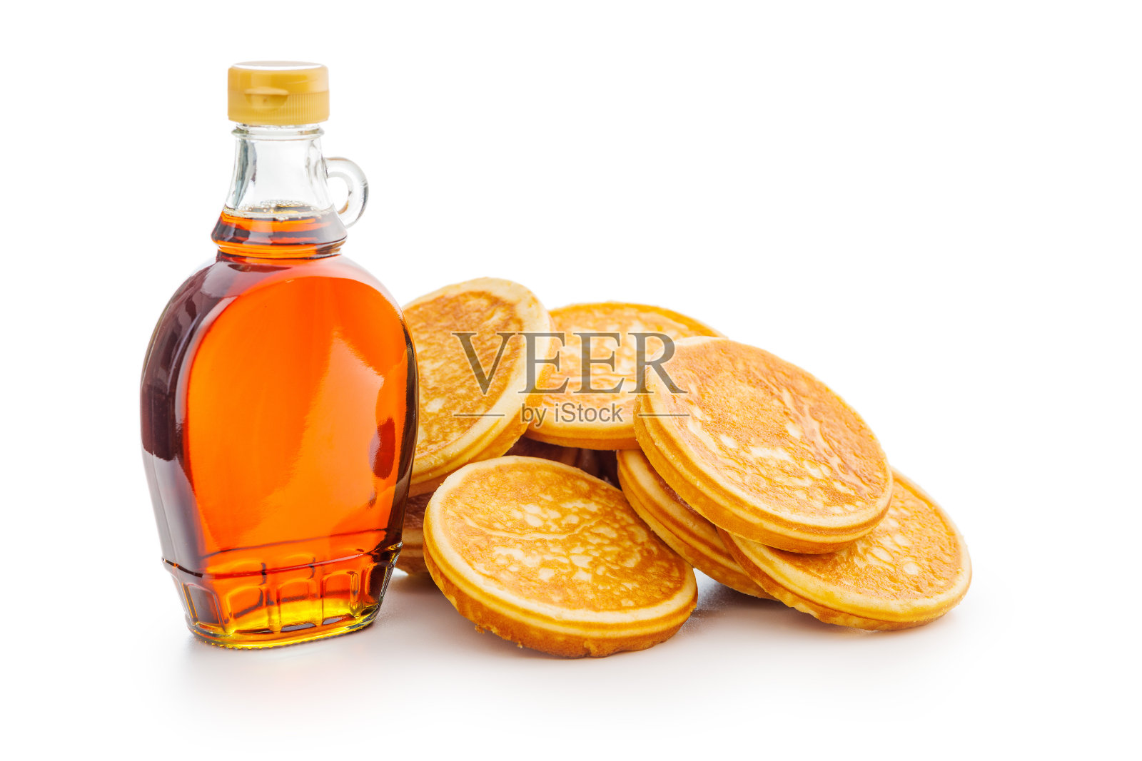 瓶子里的煎饼和枫糖浆被隔离在白色背景上。照片摄影图片