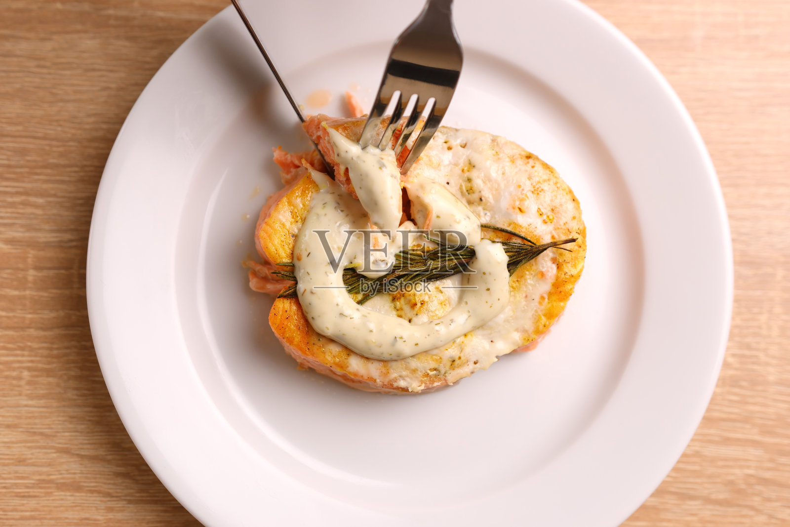 他们尝了一口加了酱汁的烤鲑鱼照片摄影图片