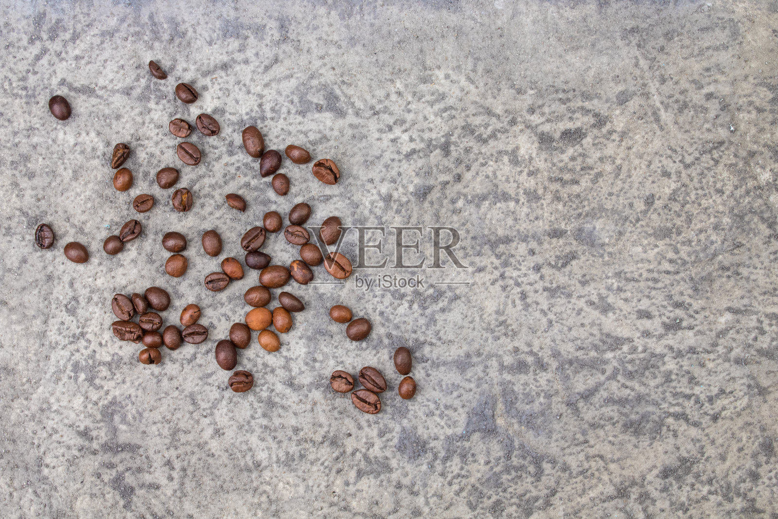 灰色混凝土背景上的咖啡豆。前视图。副本的空间。设计元素。照片摄影图片