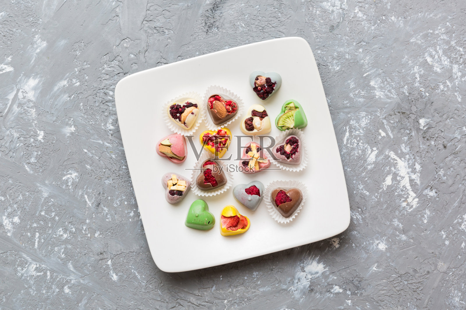 盘子与不同的巧克力在彩色背景。各种精美的巧克力俯视图与复制空间健康和肥胖的概念照片摄影图片