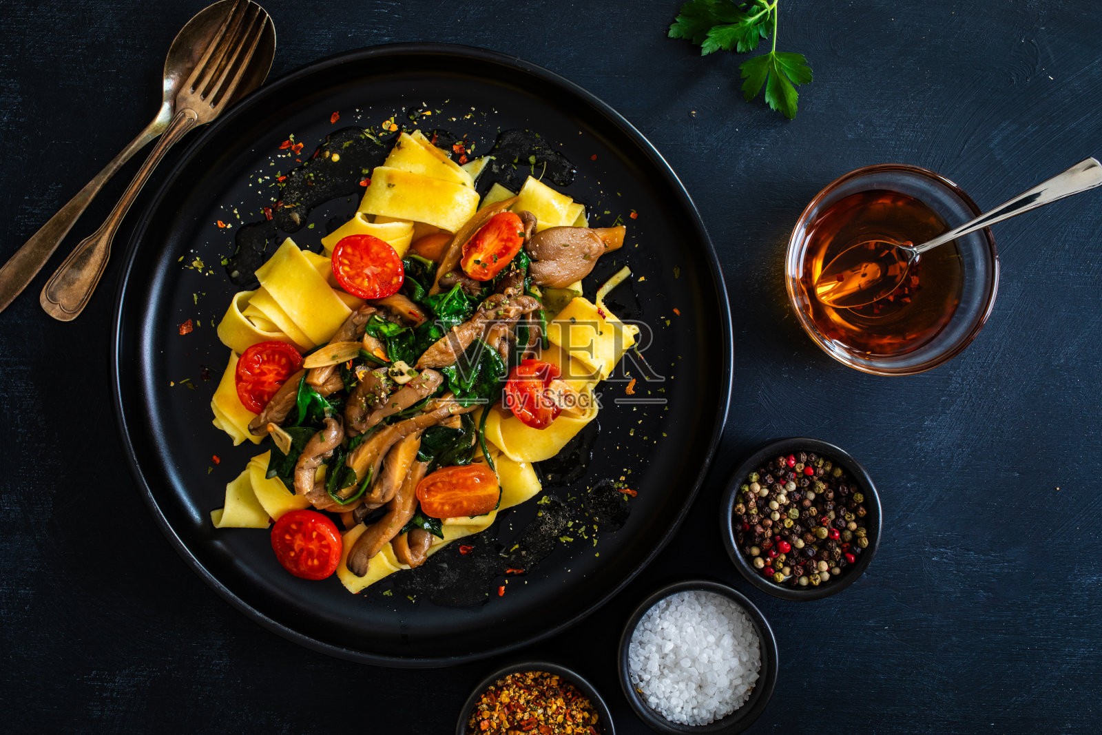 黑桌上的蘑菇菠菜西红柿面条照片摄影图片