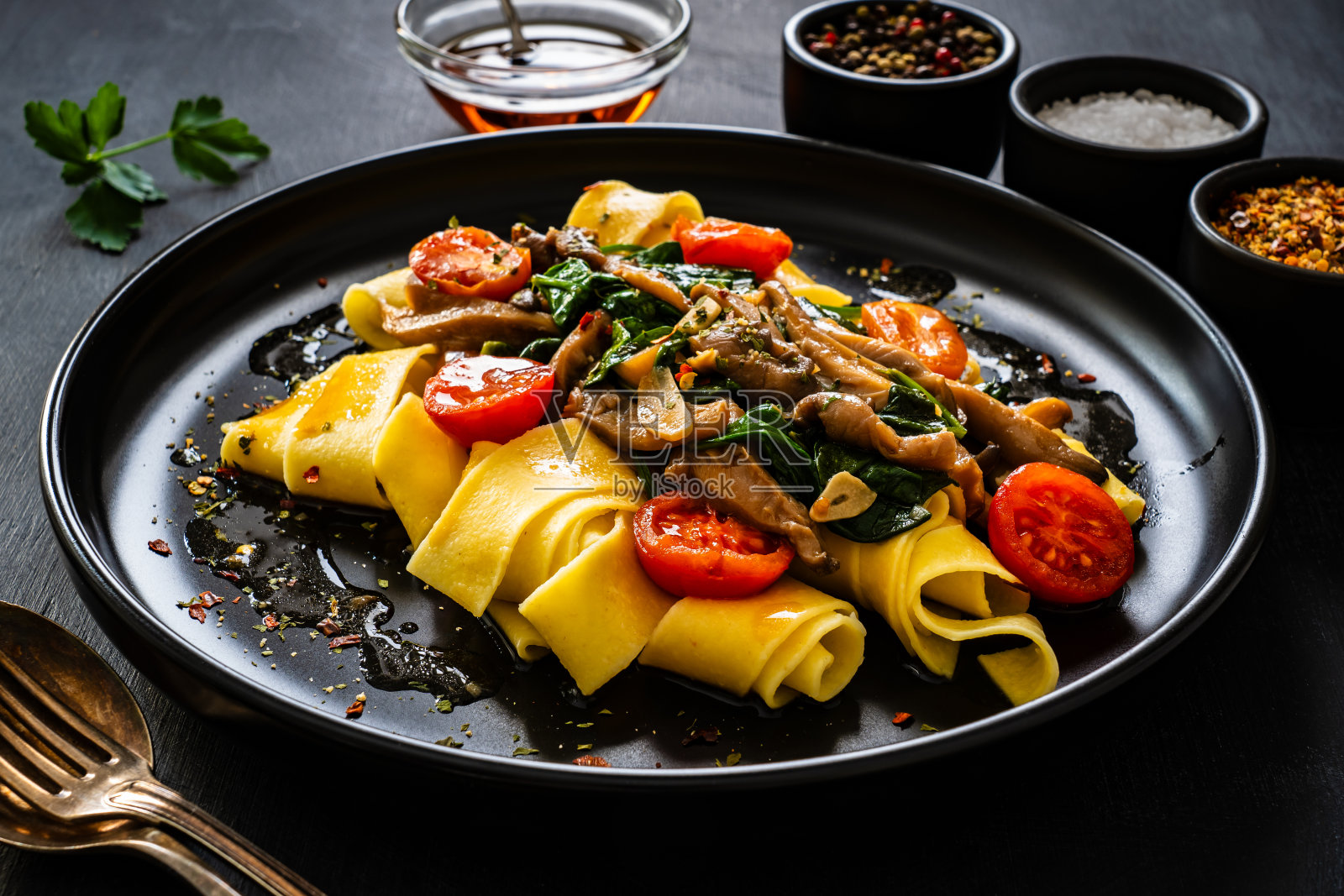 黑桌上的蘑菇菠菜西红柿面条照片摄影图片