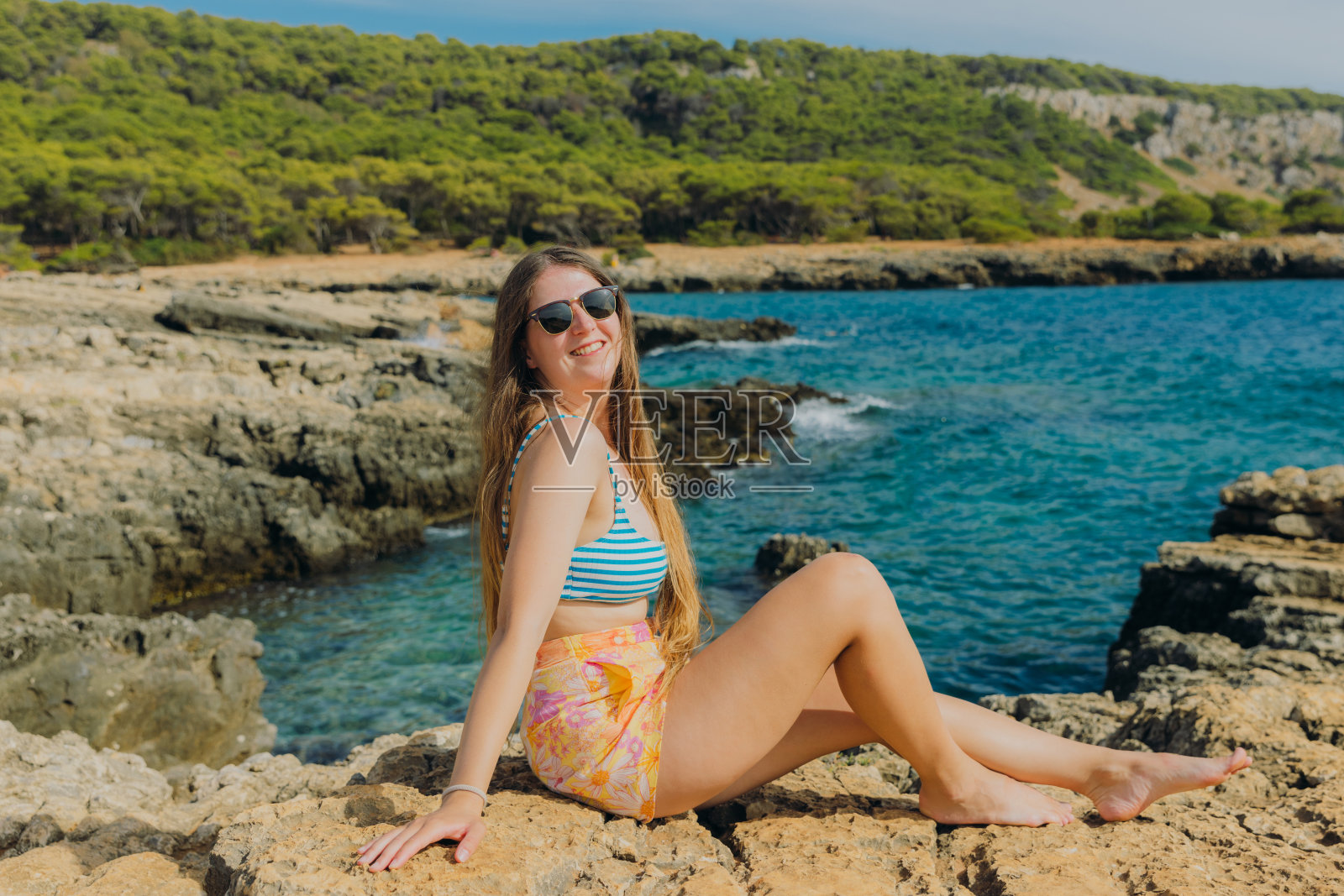 快乐的女人在意大利波尔图塞尔瓦乔的岩石海岸线上沉思夏天照片摄影图片