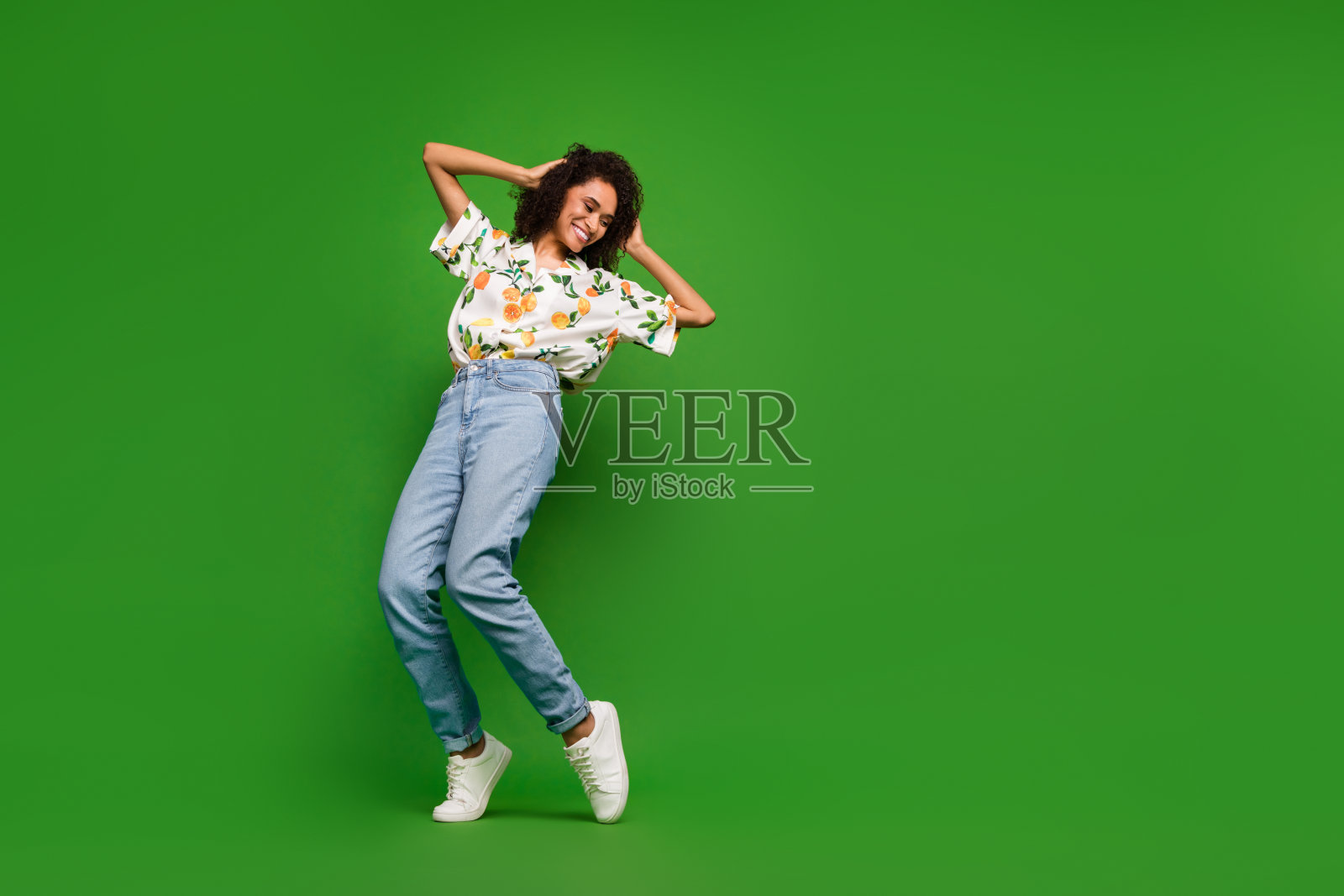 时髦积极的女人穿着印花衬衫跳舞的手头部空白空间孤立的绿色背景的全长照片照片摄影图片