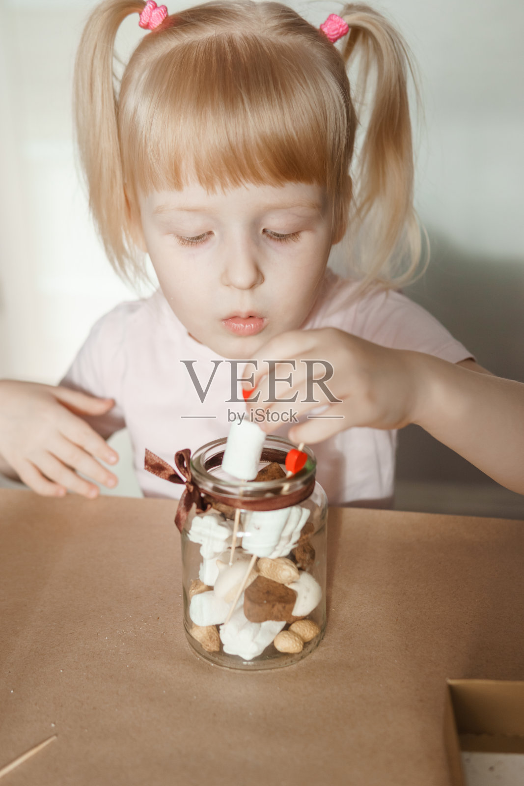 一个小女孩亲手制作了一份甜蜜的情人节礼物。一个节日礼物，一个视频博客条目。照片摄影图片