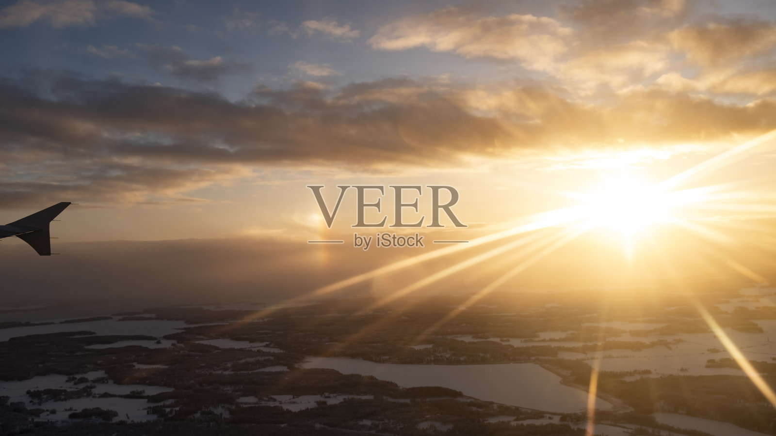 从飞机窗口看到的芬兰拉普兰地区冬日白雪皑皑的夕阳美景照片摄影图片