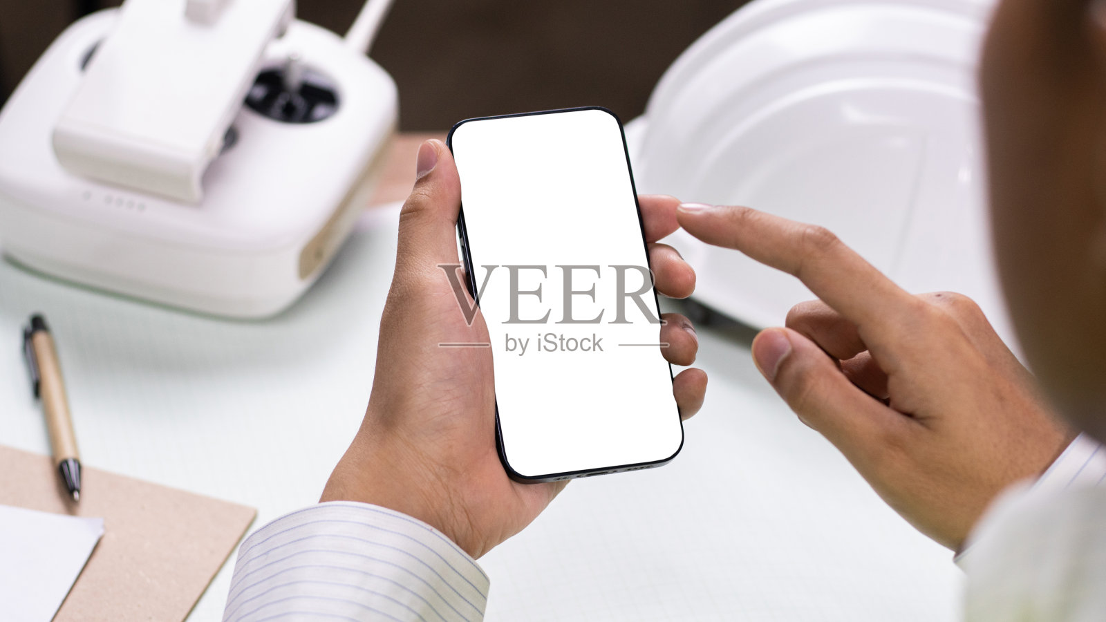 工程师站在工地上使用智能手机。回头看，工程师用笔记本电脑打字开发程序应用程序屏幕系统应用程序的开发理念。照片摄影图片