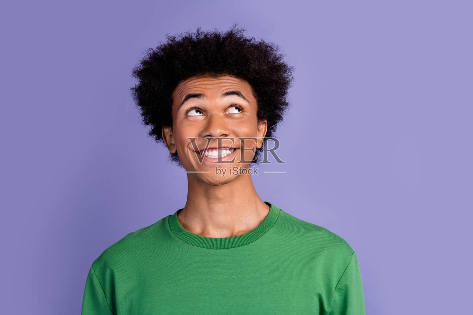 照片中心情好梦幻的男子穿着绿色毛衣，看起来空旷孤立的紫罗兰色背景照片摄影图片