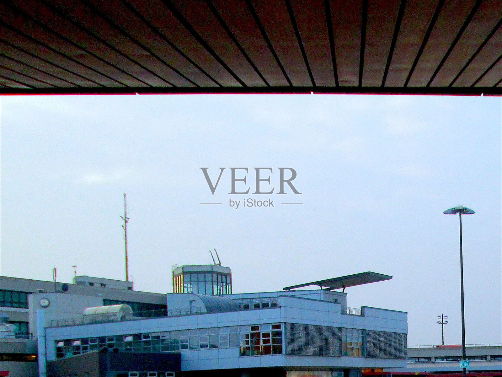 柏林多云的泰格尔国际机场航站楼，棕色门廊屋檐下的灯光照片摄影图片