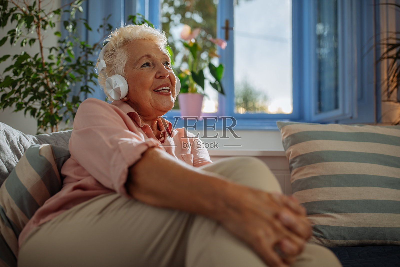 快乐的奶奶在沙发上听音乐照片摄影图片