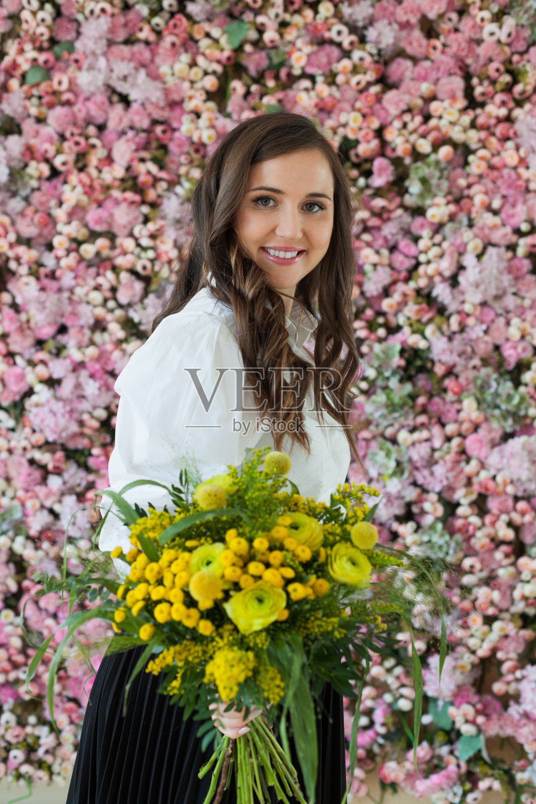 拿着花的漂亮女士。快乐的黑发女人室内画像照片摄影图片