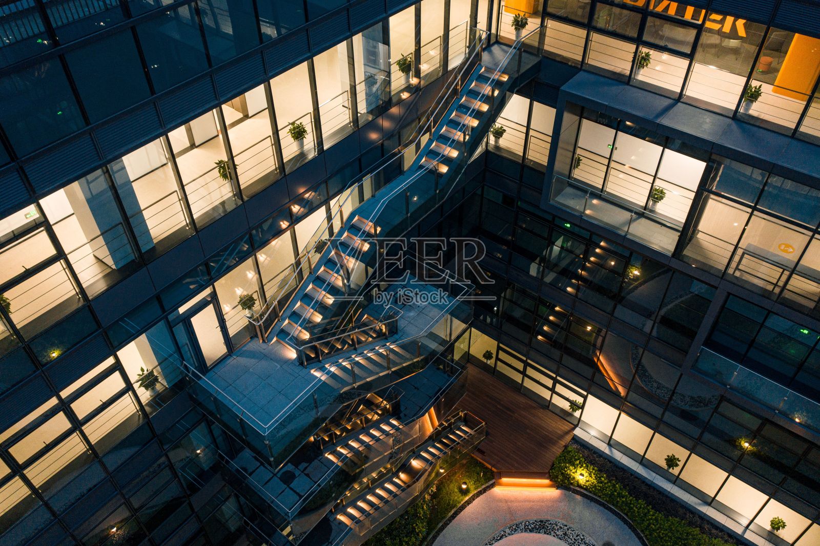 一家高科技公司的庭院花园有一个弯曲的通道，周围是透明的玻璃墙照片摄影图片