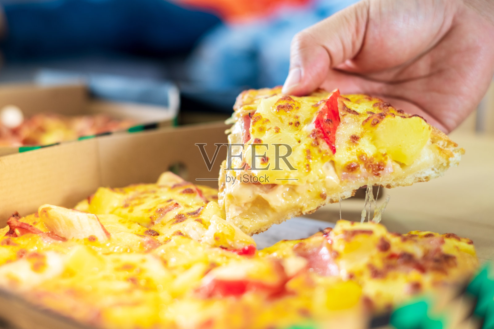 近距离的女人的手拿着一片奶酪美味的新鲜披萨，食品送回家的概念照片摄影图片