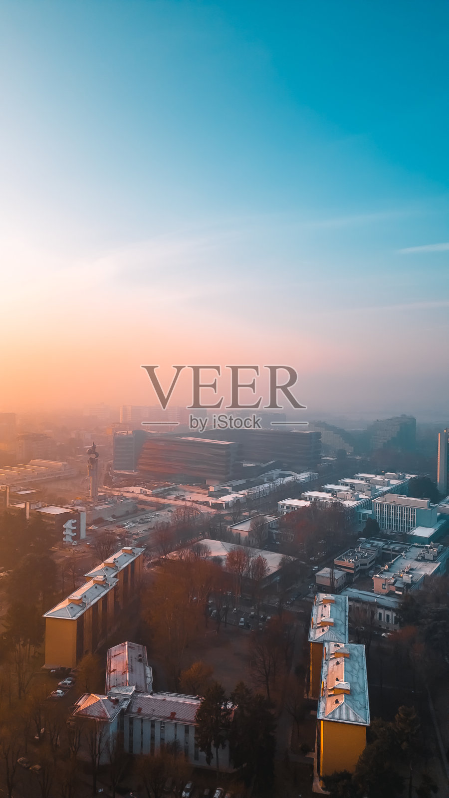 2024年2月4日，意大利米兰伦巴第，从无人机上拍摄的雾蒙蒙的日出与圣多纳托米兰天际线照片摄影图片