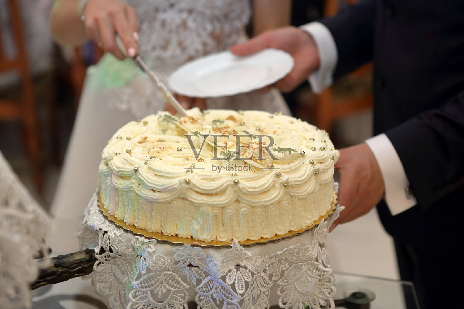 婚礼上，新娘和新郎正在切婚礼蛋糕照片摄影图片