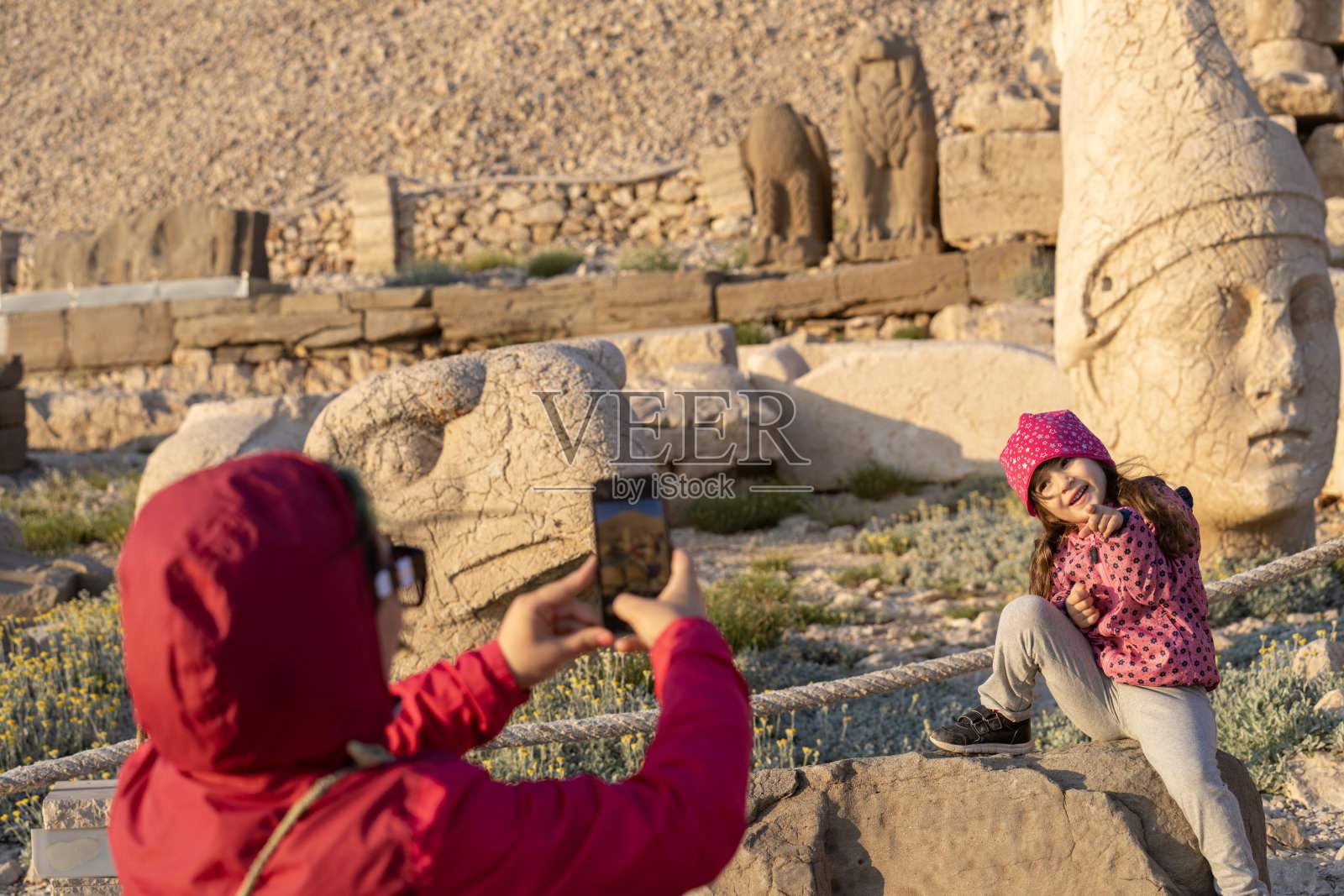 母亲在古遗址中给女儿拍照照片摄影图片