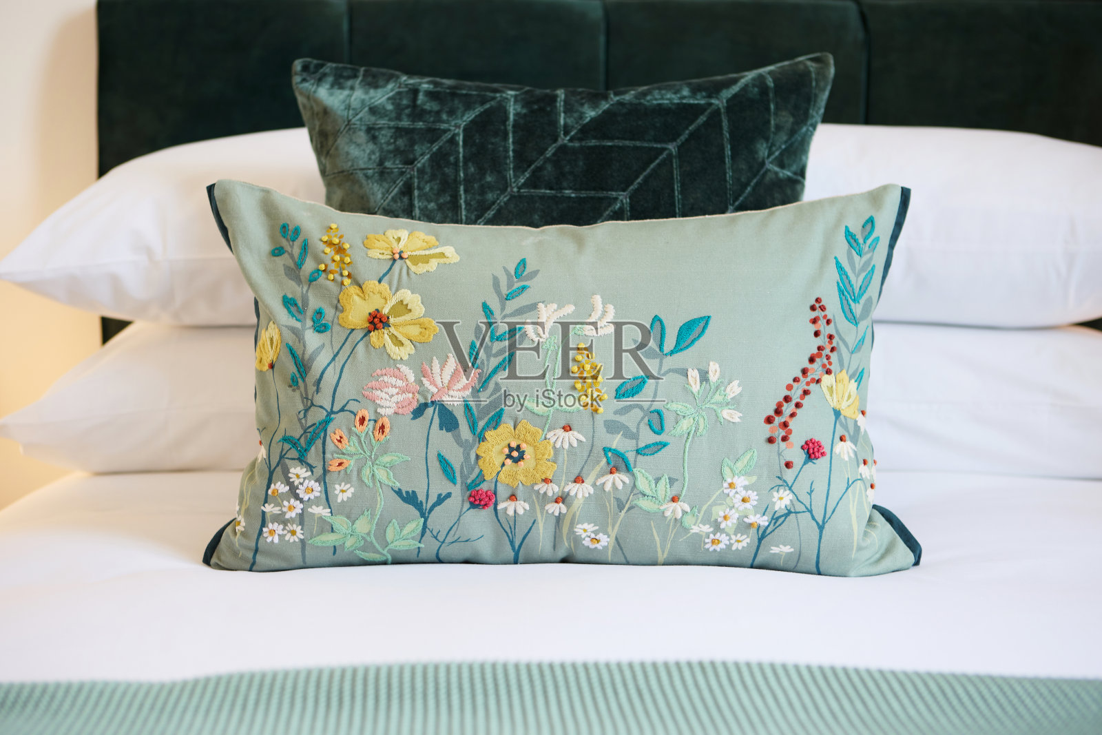 卧室内部，枕头和酒店与热情好客，舒适的住宿与家具和装饰。房间，财产或房子度假，度假或豪华度假村与花卉设计的特写照片摄影图片