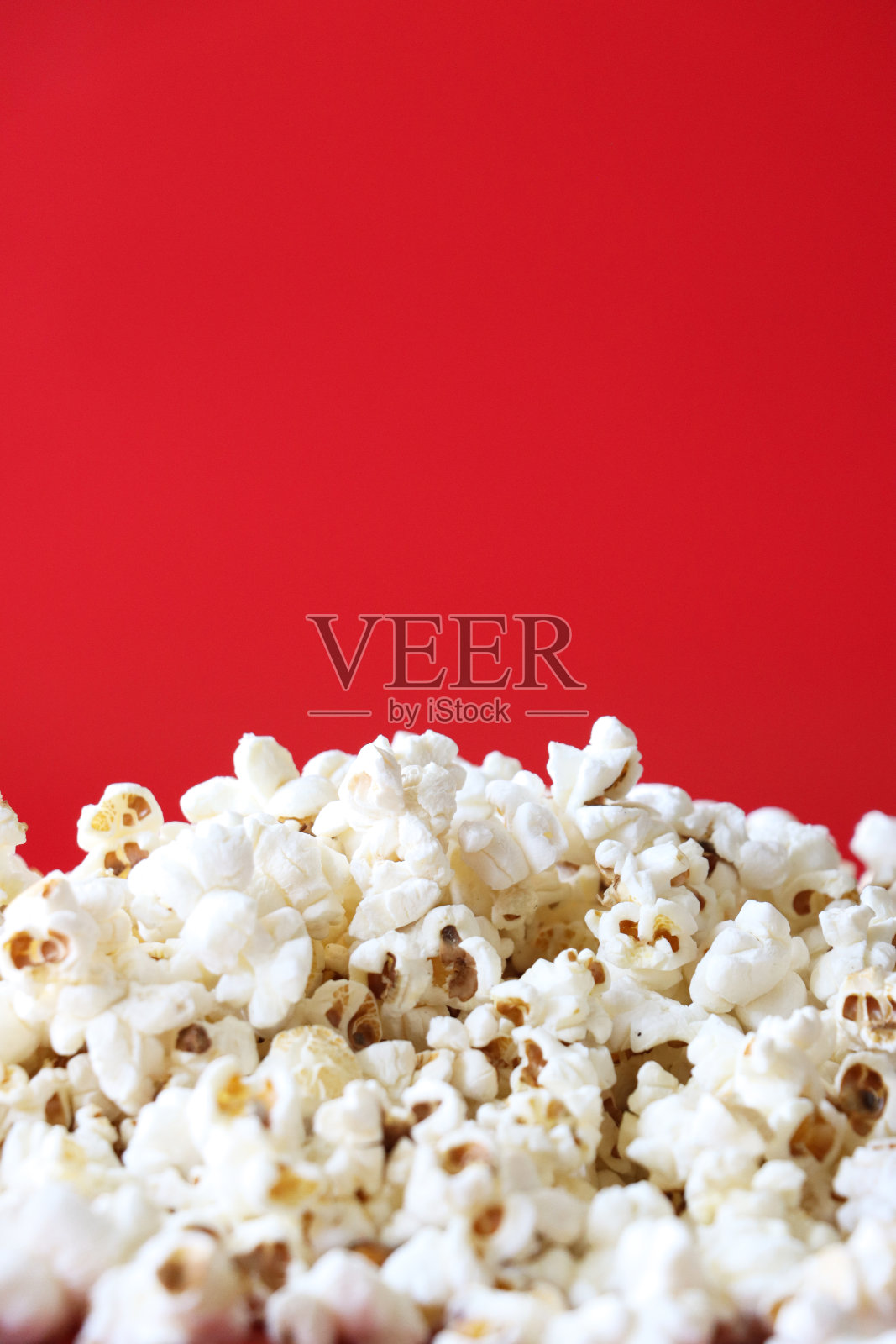 一堆爆玉米粒的特写图片，红色背景，高架视图，复制空间照片摄影图片