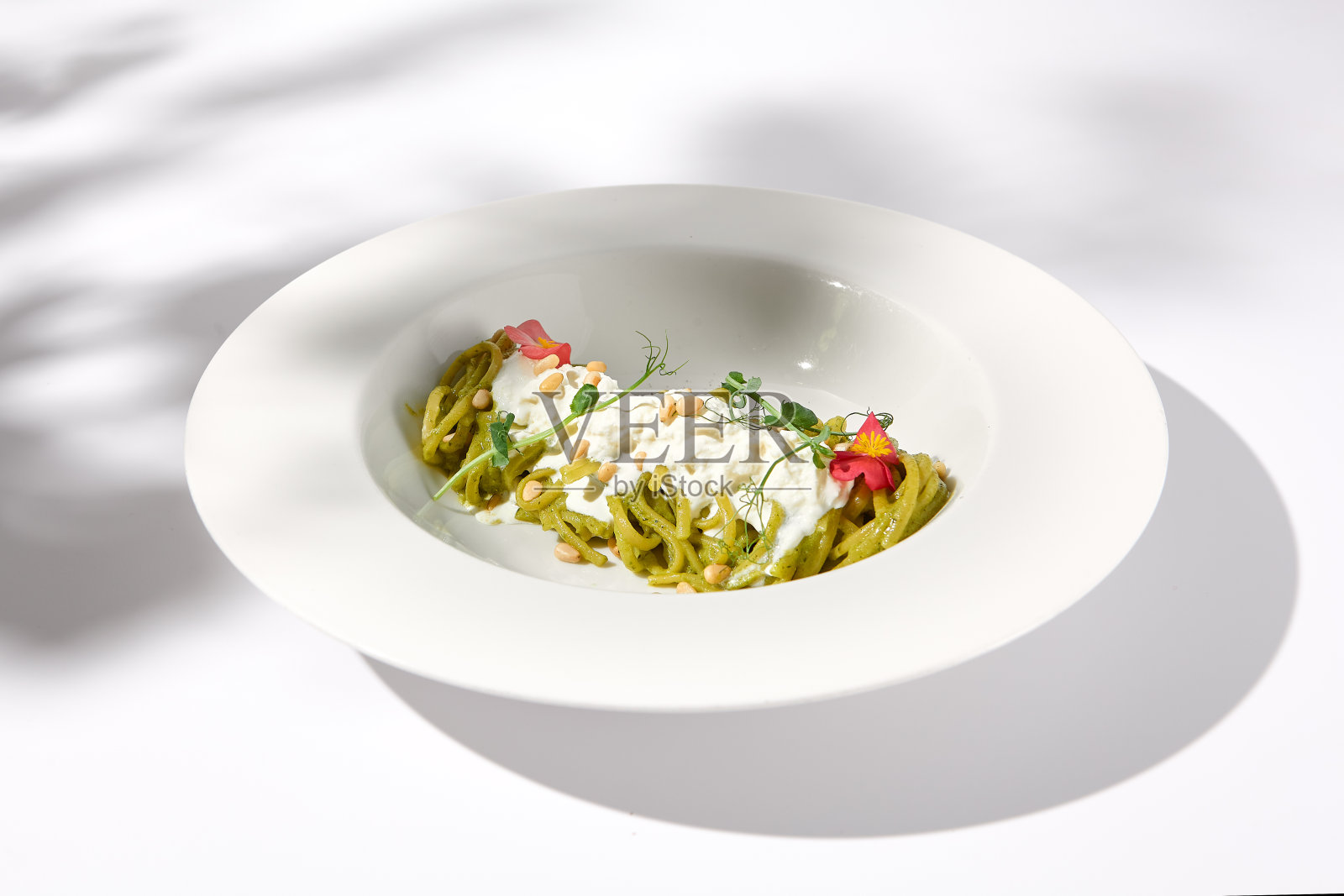 意大利面配香蒜沙司和斯特拉卡泰拉奶酪，白色的叶子的阴影，理想的季节性菜单特色照片摄影图片