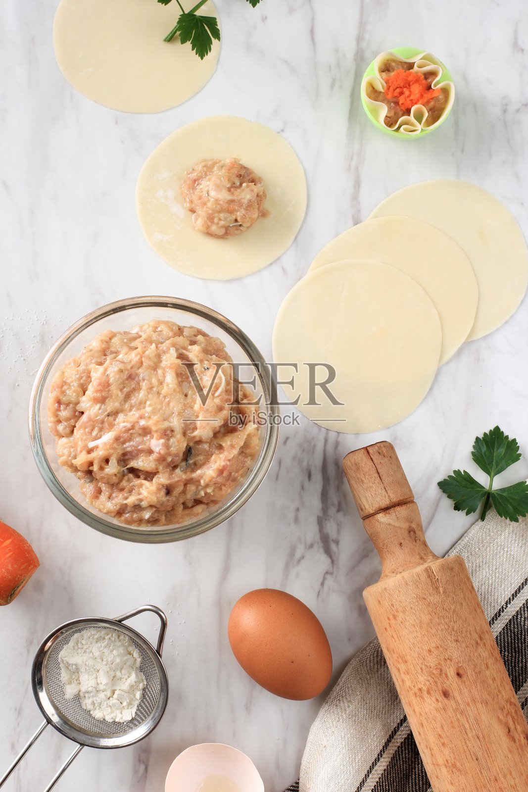 生饺子(点心)和食材在白色大理石背景上的构图。文字的复制空间，煮肉的过程，蒸点心照片摄影图片