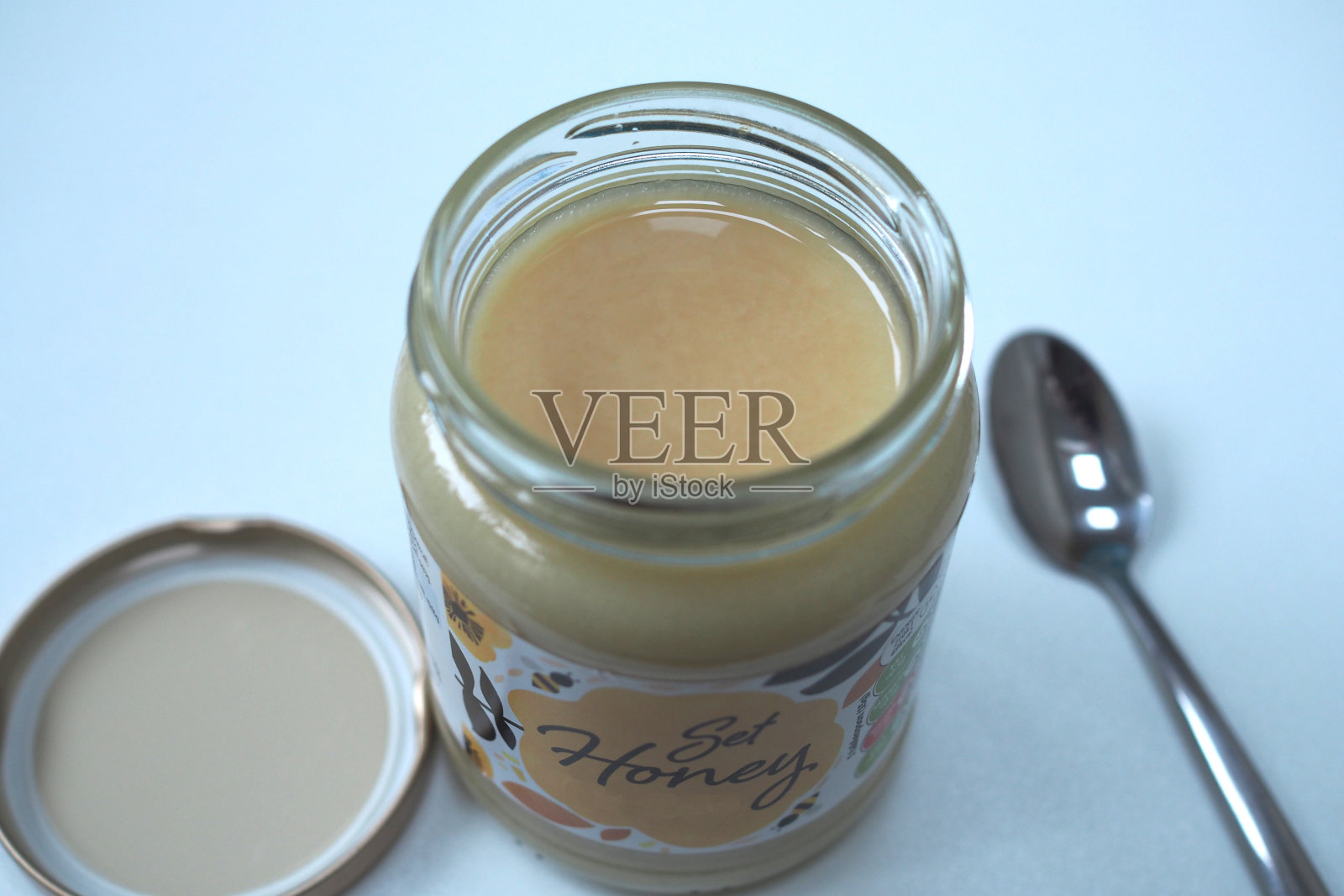 用勺子打开蜂蜜罐照片摄影图片