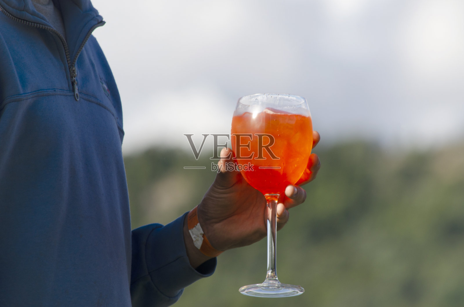 度假时手里拿着鸡尾酒，手里拿着橙汁照片摄影图片